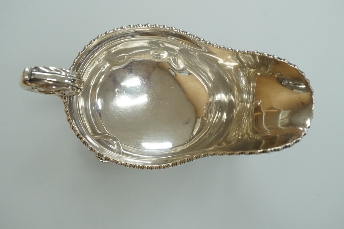 An Edwardian silver sauceboat, by The Goldsmiths & Silversmiths Co Ltd, London, 1903, with flying scroll handle and gadrooned border, length 16.3cm, 9.5oz.